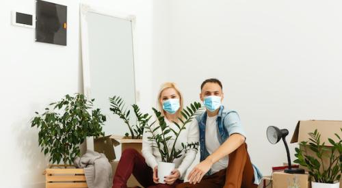 couple masked in house moving boxes