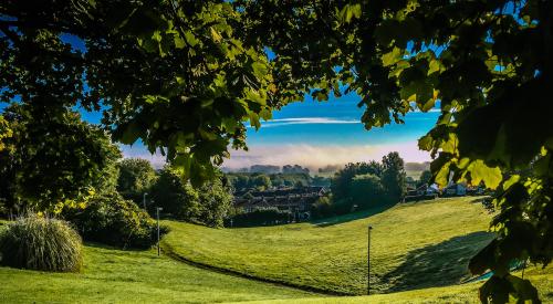 Rolling green hill overlooking residential area