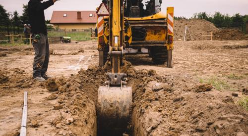 Crane digging into dirt on housing site