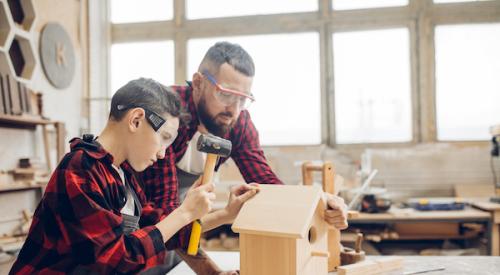 man and boy working on making DIY birdhouse 