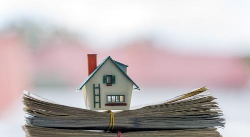 Small house model on top of stack of cash