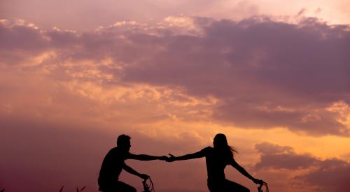 Couple riding bikes, holding hands