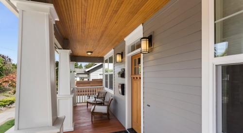 Finished front porch with wood trim and gray siding