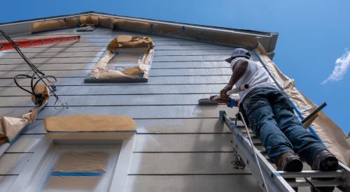 Painter painting exterior of house under renovation