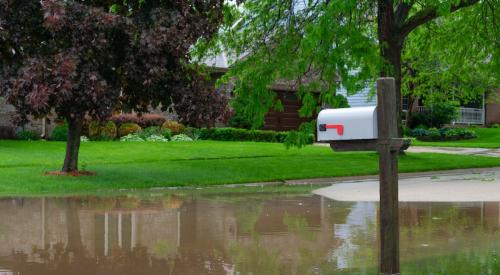 Mailbox next to flooded street in residential neighborhood