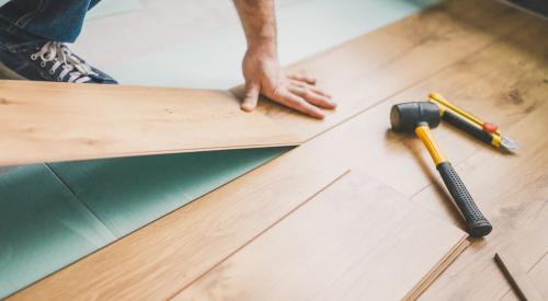 Person pulling up hardwood floor 