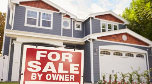 Red for-sale by owner sign outside of blue single-family house with white trim