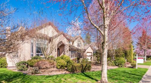 Brick residential house with for-sale sign in front yard