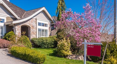 Red for-sale sign in residential lawn