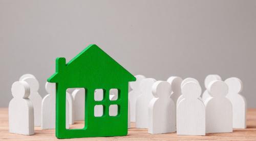 White figurines surrounding green house