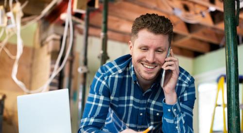 Happy home builder on phone