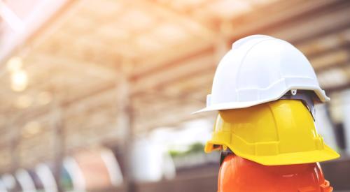 Yellow, orange, and white hard hats stacked 