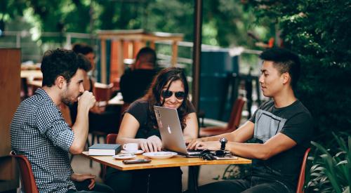 Young people working on laptop at café table