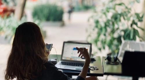 Woman investor at a desk with phone in hand