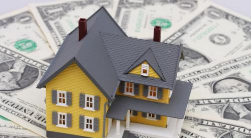 Yellow house model surrounded by cash