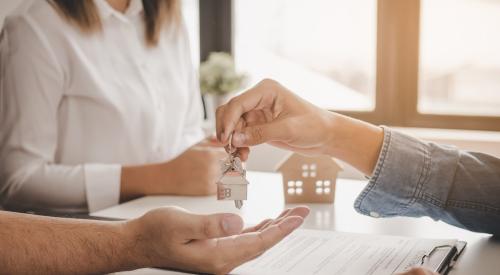 Agent handing over house keys to buyers