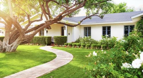 Suburban home exterior and front lawn with curved pathway to front door