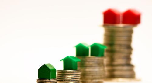 Green and red houses on different sized stacks of coins representing homeownership gap