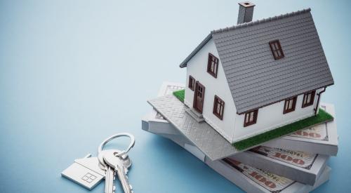 House model on top of stack of money next to house keys