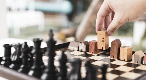 Small wooden houses on chess board