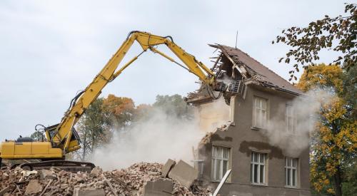 Bulldozer tearing down house