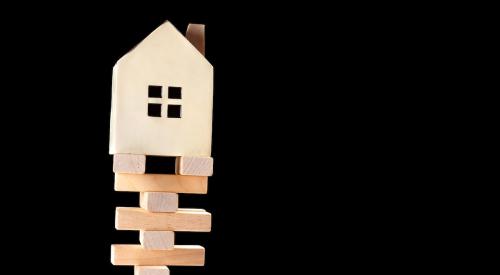 Wooden model home on top of jenga logs