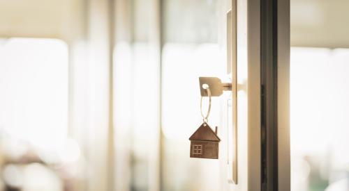 House key hanging from lock in door