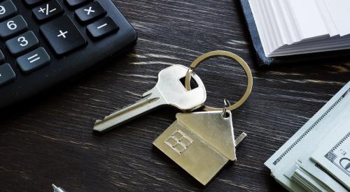 House keys next to calculator and stack of cash