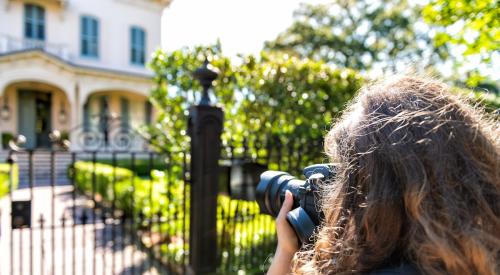 Women taking photograph of house exterior