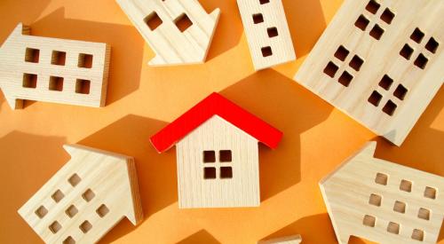 Wooden house with red roof surrounded by other wooden houses