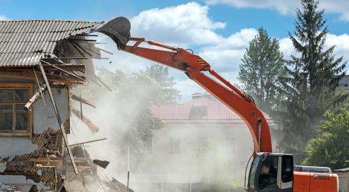 Residential house being torn down by crane