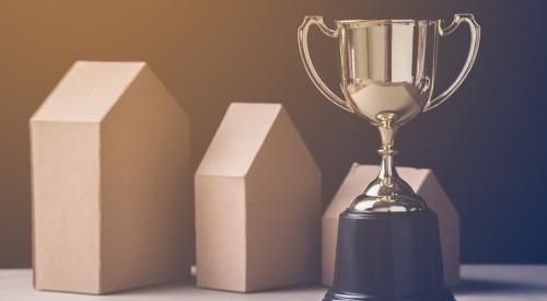 Golden trophy next to small wooden houses