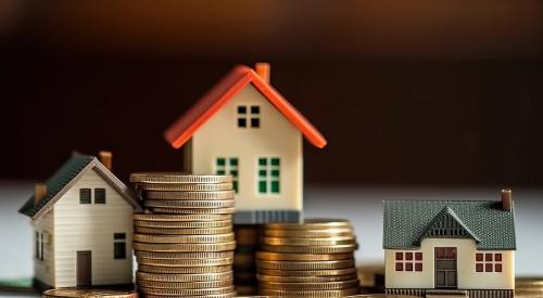 Small houses surrounded by stacks of coins