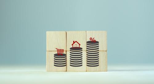 House, shopping cart, and percentage stacked on coins displayed on wooden blocks 