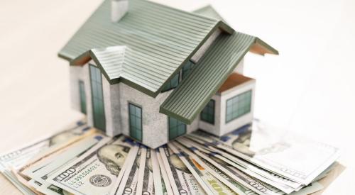 Small house model on stack of cash