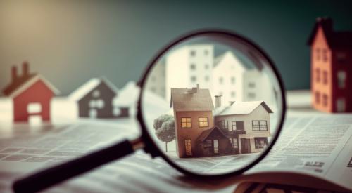 Houses and paperwork under magnifying glass