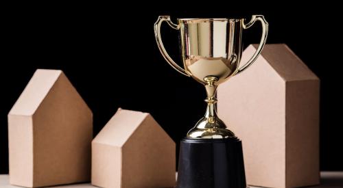 Golden trophy next to wooden houses