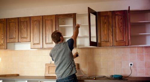 contractor installing new kitchen cabinets in home