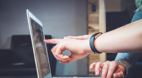 People using a laptop, pointing at the screen