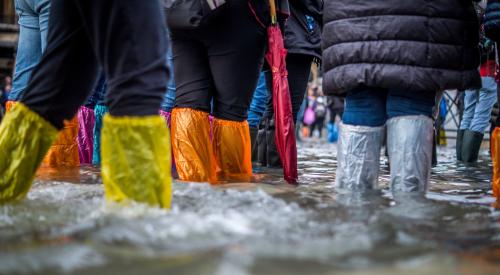 People walking through flooded street