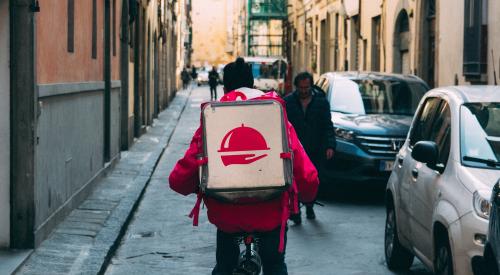 Delivery person on bicycle on street