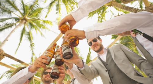 Group of men clinking beer bottles