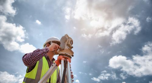 Land surveyor with a blue sky background