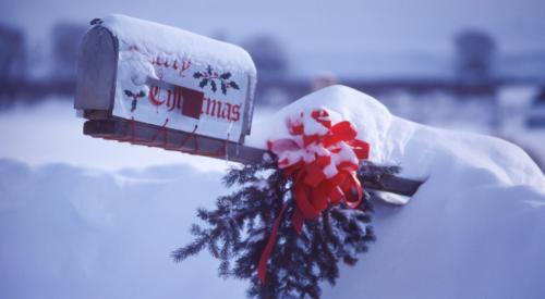 Mailbox with holly covered in snow