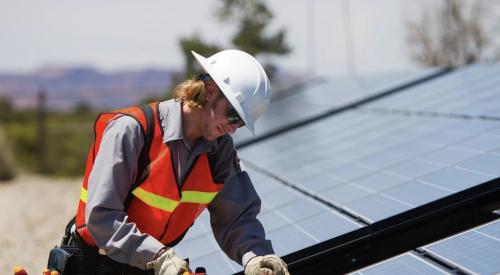 Man installing solar panels on roof