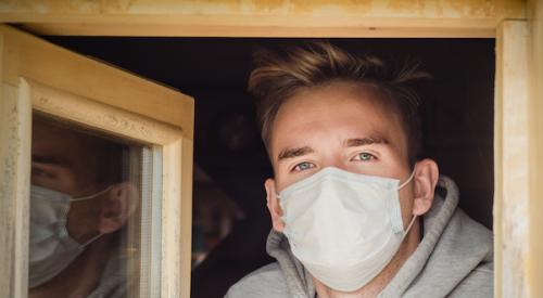 Man opening a window with mask on