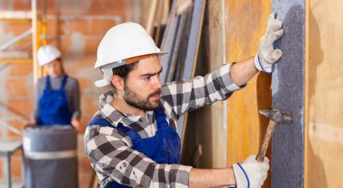 Man sheathing a wall