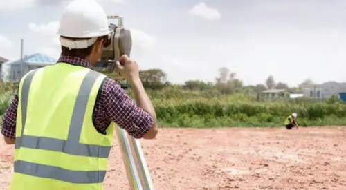 Surveyor surveying land for home builder acquisition and development