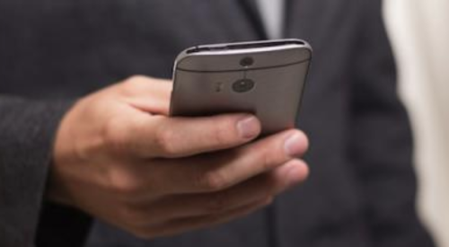 Man using his cell phone to respond to a sales lead