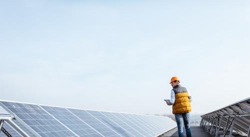 Man walking inspecting solar panels